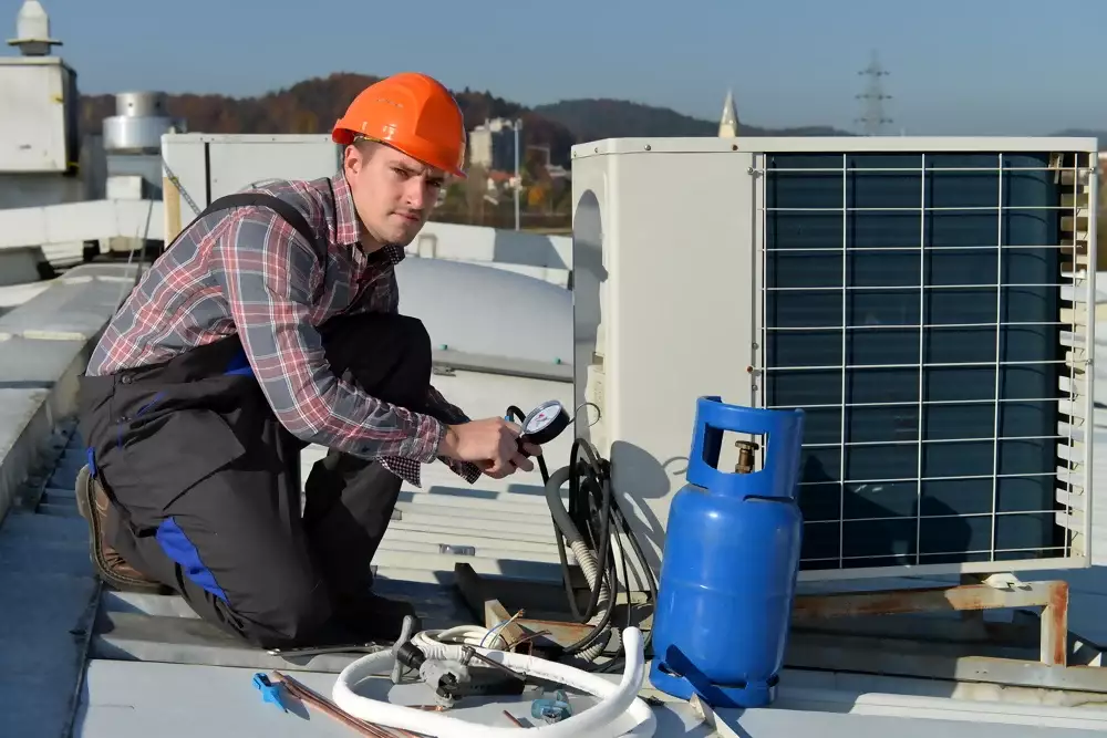 Contractor-repairing-air-conditioning-unit-on-the-roof